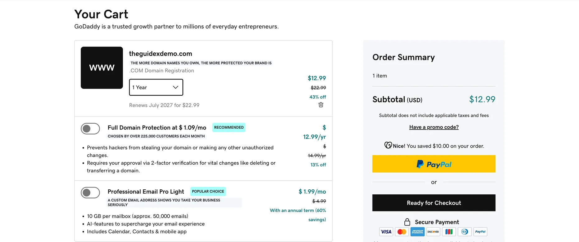 GoDaddy cart with a .COM at a one-year term, the domain-protection and email upsells toggled off, and a Have a promo code link in the order summary